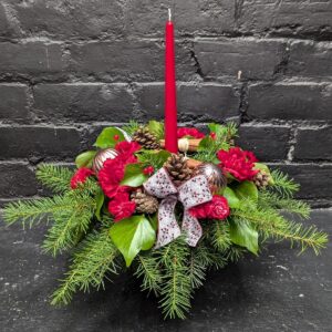 Christmas flower candle with red blooms and greenery