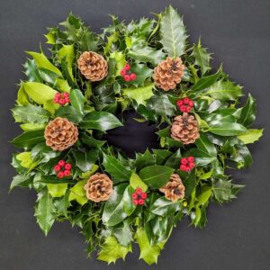 Holly graveside Christmas wreath with pinecones and red berry accents