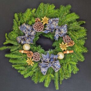 Navy and gold pine Christmas door wreath with bows, gold baubles, pinecones, lotus pods and cinnamon