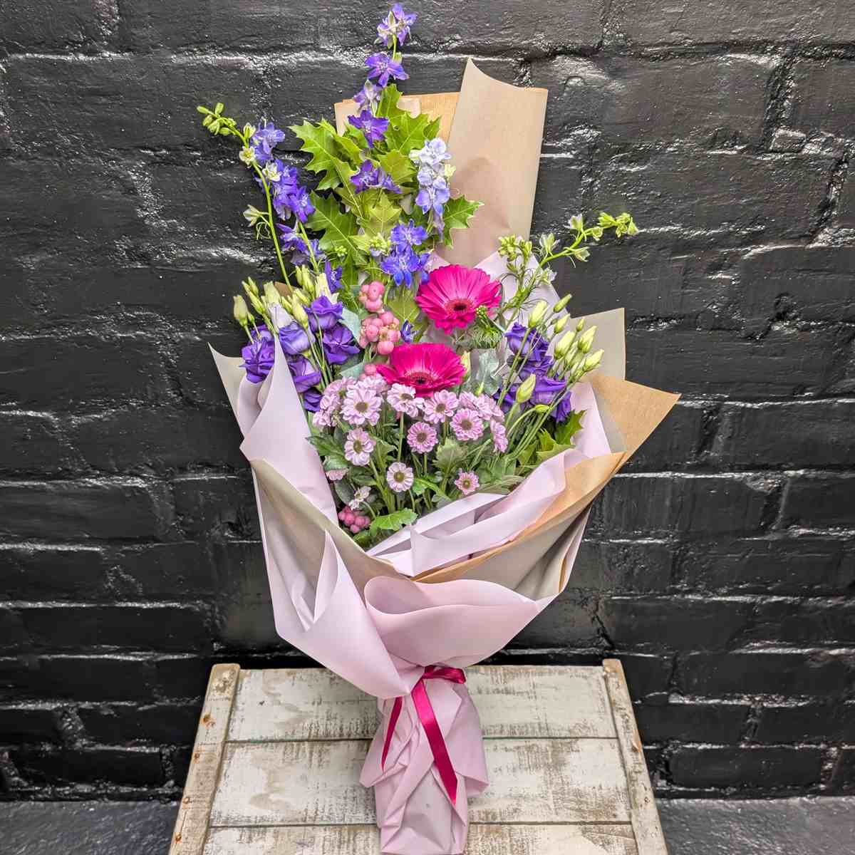 Electric Iris Bright pink and purple hand-tied bouquet with gerberas, lisianthus and seasonal flowers in lilac and kraft wrap, tied with a pink ribbon – Anastasia Florists Aberdeen - Close up