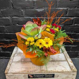 Bring the warmth of autumn into your home with this unique Pumpkin Delight arrangement. Artfully arranged inside a real pumpkin container, featuring vibrant gerberas and chrysanthemums. Available for Same-Day Delivery in Aberdeen - Side View