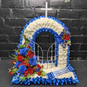 Red, white and blue Gates of Heaven funeral tribute with white chrysanthemums, white cross, open gates and red and blue rose sprays.