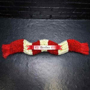 Red and white funeral tribute in the shape of a football scarf