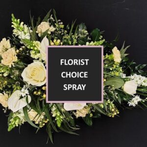 Florist choice single ended funeral spray in white and cream flowers with green foliage and a central box reading “Florist Choice Spray”.