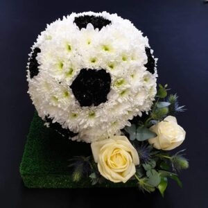 Floral football tribute with white roses and greenery