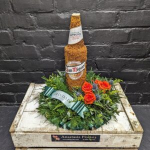 Funeral tribute with beer bottle and flowers