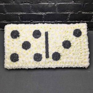 Funeral domino floral tribute massed with white chrysanthemum, with black flower pips and a central dividing bar