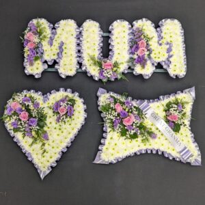 MUM letter, heart and cushion funeral tribute set in white chrysanthemums with lilac ribbon edging and pink and purple flower sprays.