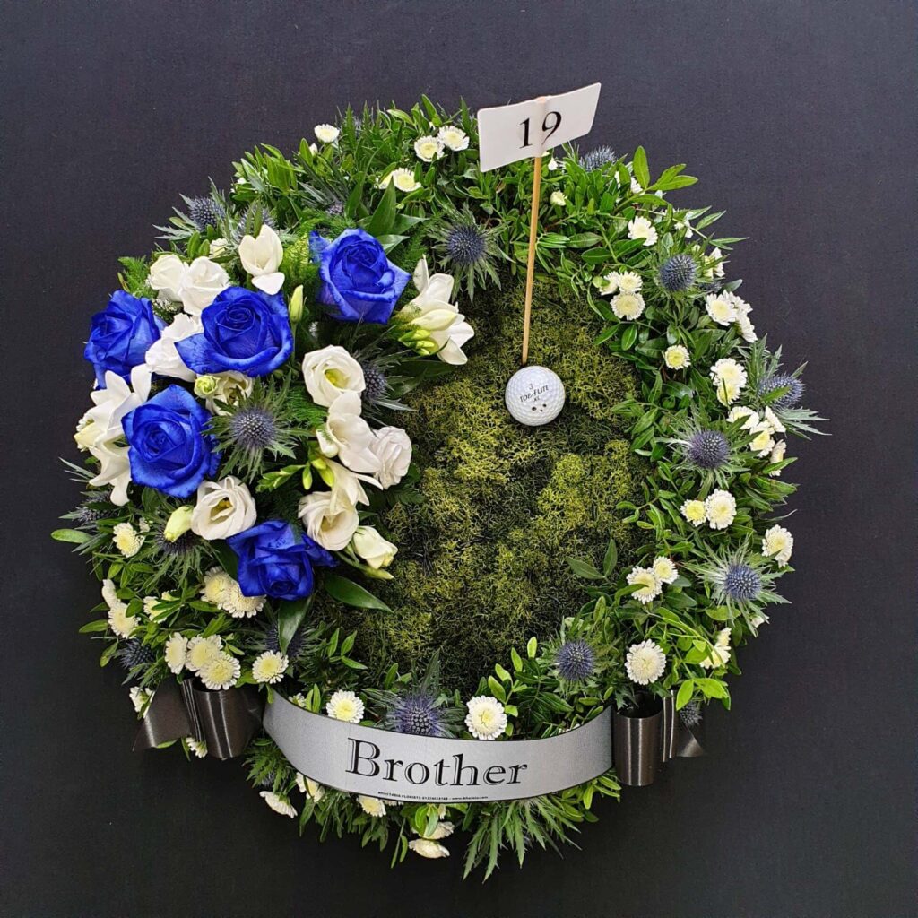 What Flower Arrangements are Suitable for a Male Funeral? Golf funeral Flowers with blue and white blooms and Golf Ball