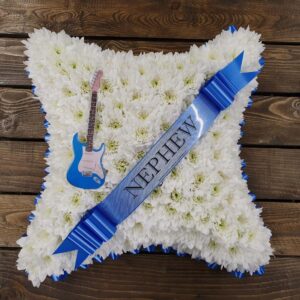 Guitar funeral cushion tribute with white chrysanthemum base and blue ribbon