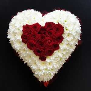 Heart-shaped funeral flower arrangement with red roses and white chrysanthemums