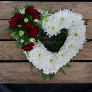 Heart-shaped floral tribute with white chrysanthemums and red roses