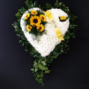 White chrysanthemum heart funeral tribute with yellow sunflowers, greenery and yellow Mum ribbon on a black background