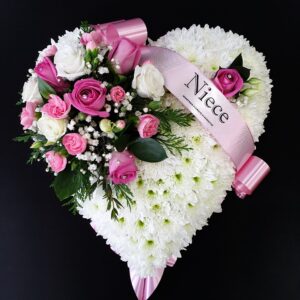 Heart-shaped funeral flower tribute with white chrysanthemums and pink roses.