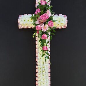 Pink and white funeral cross with chrysanthemum base, pink roses and gerberas