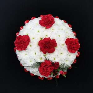 Red and white funeral posy with white chrysanthemum base and red carnations