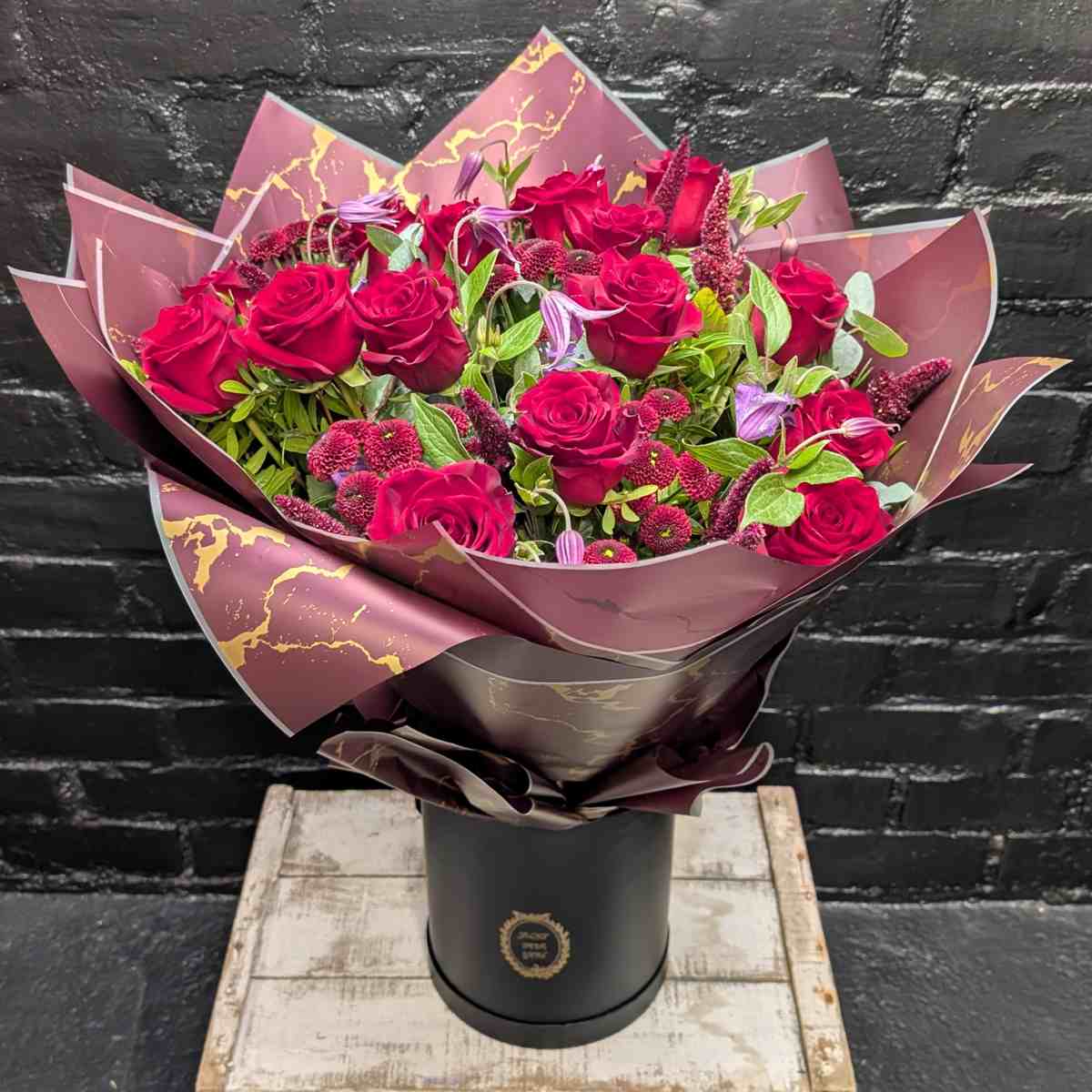 Ruby Romance Hand-Tied Bouquet Ruby Romance hand-tied bouquet of red roses and seasonal flowers in marbled wrap and black hat box – Anastasia Florists Aberdeen