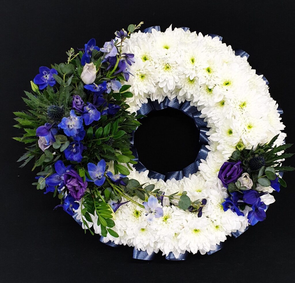 Funeral Flower Tributes Explained: Coffin Sprays, Wreaths, Hearts, Posies & More White and blue funeral flower wreath