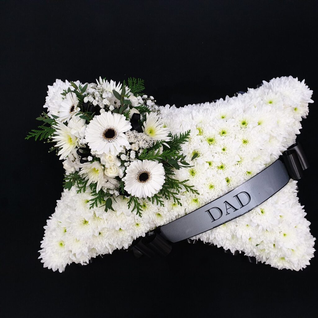 What Flower Arrangements are Suitable for a Male Funeral? Dad white gerbera funeral pillow tribute with white chrysanthemum base and black ribbon