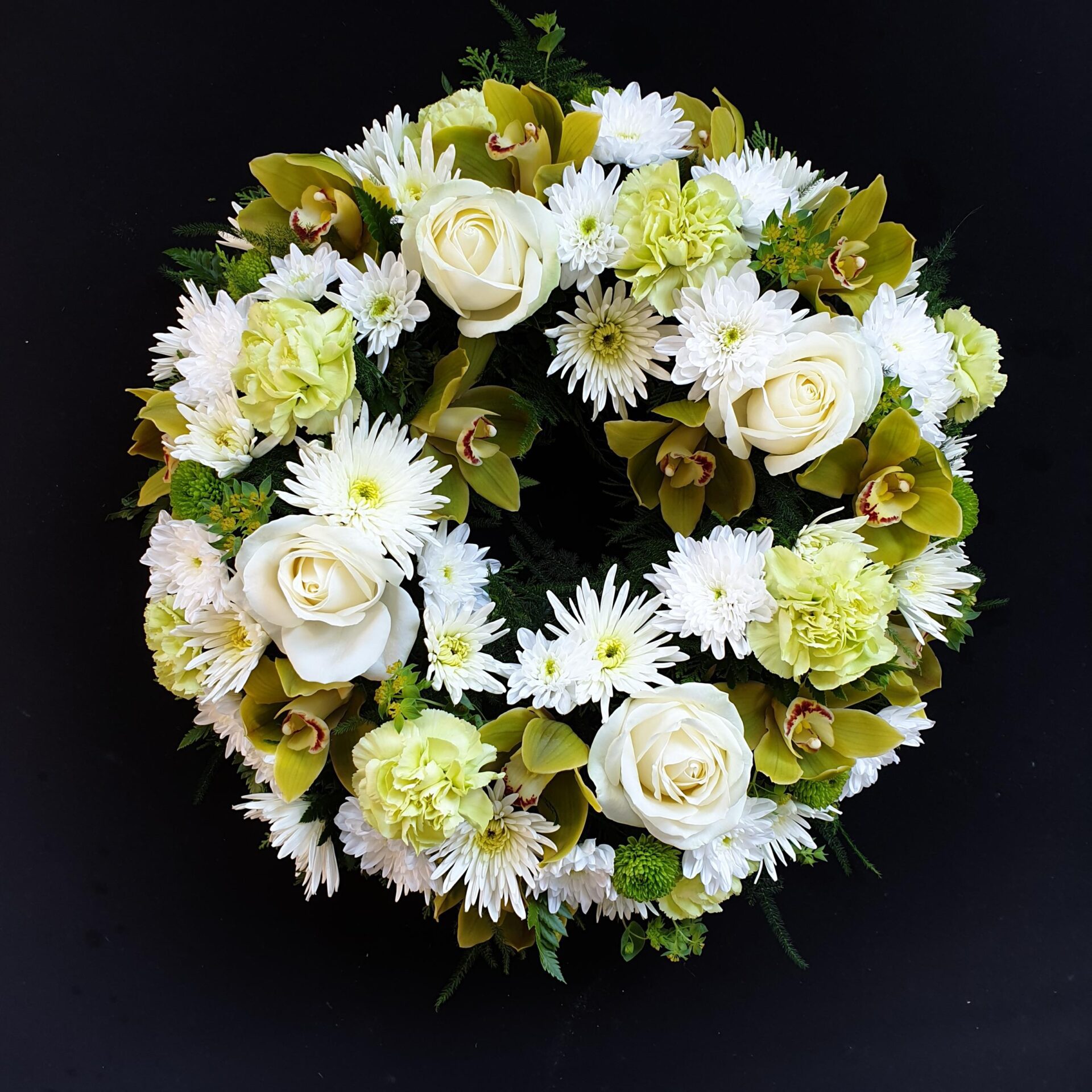 White and green funeral wreath with roses, orchids, carnations and chrysanthemums