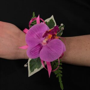 Pink orchid wrist corsage with green foliage