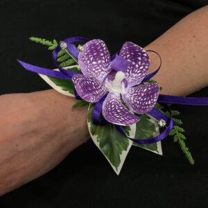 Purple orchid wrist corsage on arm