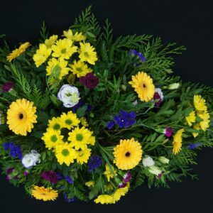 Yellow and purple funeral flower spray arrangement