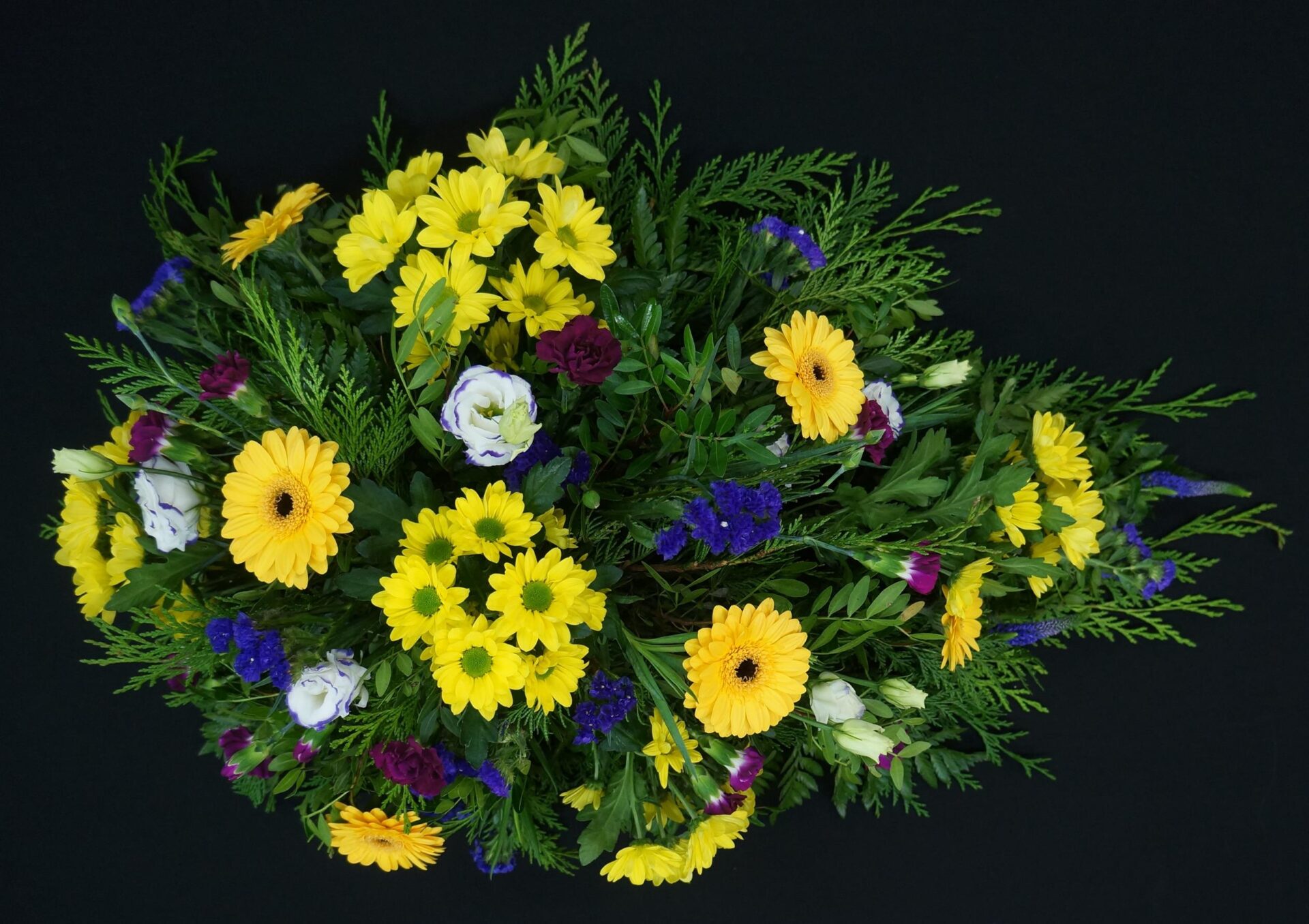 Yellow and purple funeral flower spray arrangement