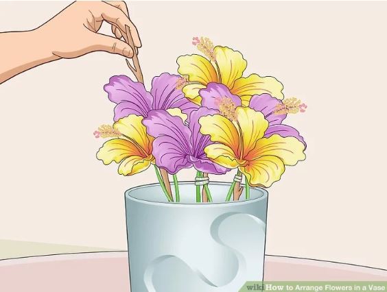 Man add Tree Branches to Support Flower