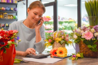 A woman on the phone in a florist shop