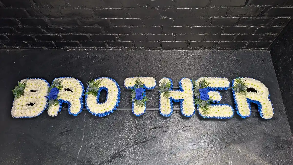 Brother Funeral Letter Tribute in Blue & White Wide View of Brother funeral letter tribute in blue and white flowers displayed on a frame