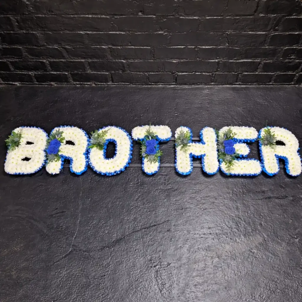 What Flower Arrangements are Suitable for a Male Funeral? Brother funeral letter tribute in blue and white flowers displayed on a frame