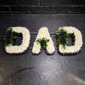 Dad funeral letter tribute in black and white flowers arranged on a frame