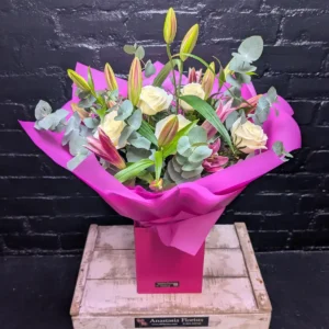 Flower Bouquets Lily and Rose Flower Bouquet with white roses and pink lilies in purple gift wrapping and a matching purple box.