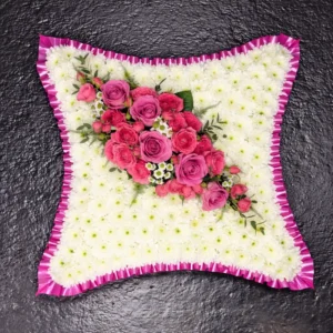 Pink rose funeral flower cushion with white chrysanthemums and pink ribbon edging