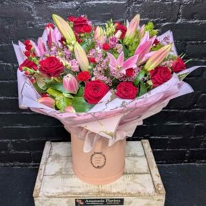 Anastasia Florists — Your Aberdeen Florist Since 1995 A luxury floral hatbox arrangement of red roses and pink lilies in a marble-patterned wrap, handcrafted by Anastasia Florists Aberdeen.