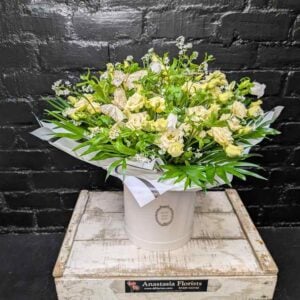 Anastasia Florists — Your Aberdeen Florist Since 1995 A pristine white floral hatbox filled with cream roses, white flowers, green foliage, and decorative gold butterflies by Anastasia Florists in Aberdeen.
