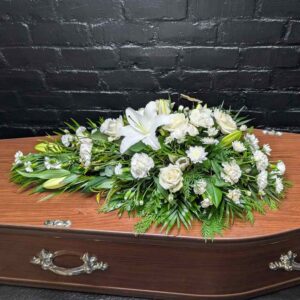 Classic white lily and rose single-ended funeral spray with delicate butterfly accents, hand-crafted by Anastasia Florists in Aberdeen.
