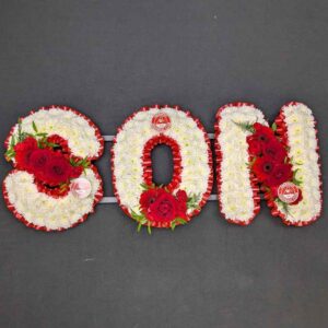 SON funeral floral letters in red and white team colours, massed with white chrysanthemums and red roses, carnations and germini