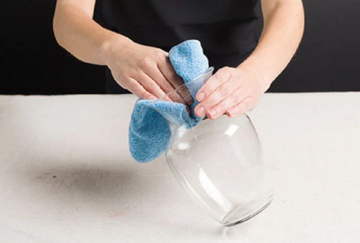 A woman Cleaning a Glass Vase