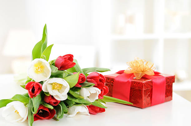A bunch of flowers with a red gift present
