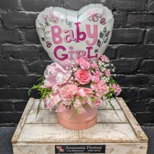 Pink baby girl flower arrangement with balloon