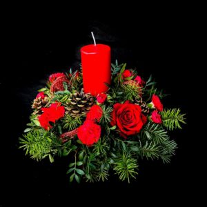 Christmas candle table centre with red flowers and greenery
