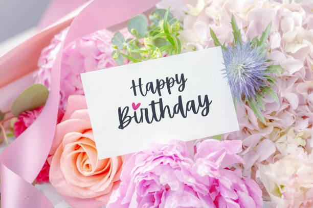 Vibrant pink flowers with a happy birthday card