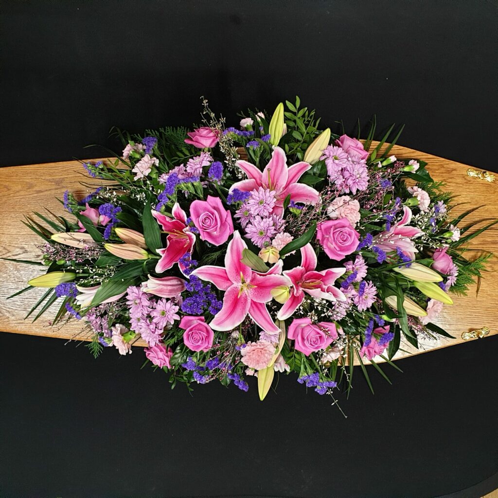 A funeral coffin spray is placed on a coffin