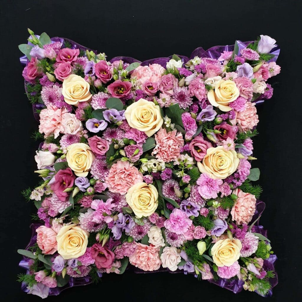 A pink funeral cushion with flowers for girls