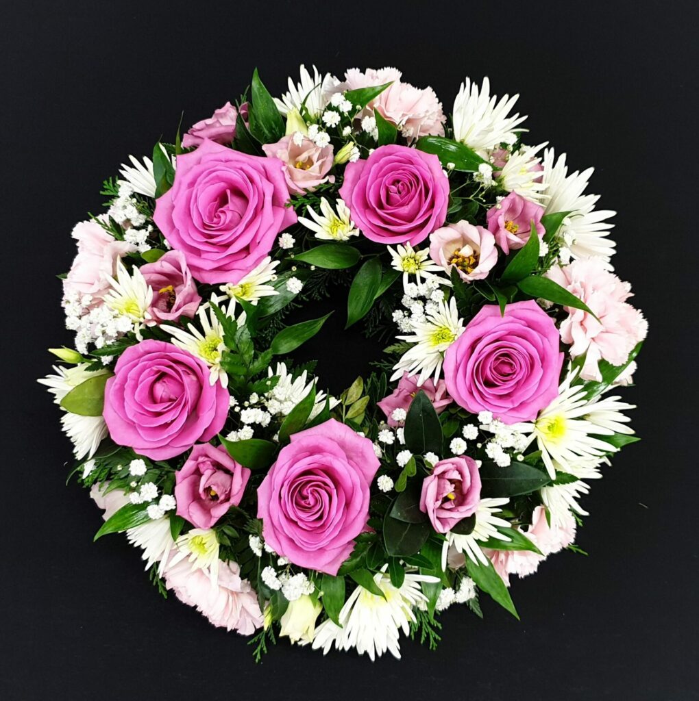 A funeral wreath with pink roses for a woman