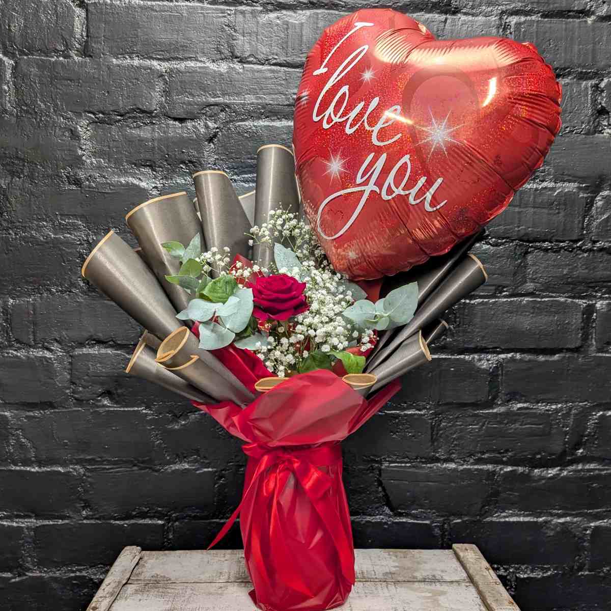 Heartfelt Message Arrangement 3 Single red rose arrangement with white Gypsophila, eucalyptus, and a large heart-shaped 'I Love You' balloon
