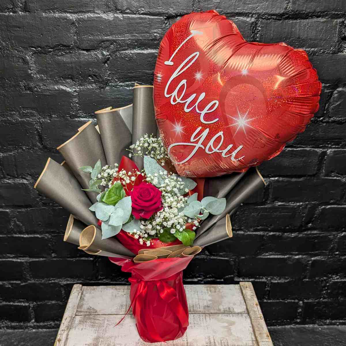 Heartfelt Message Arrangement Single red rose arrangement with white Gypsophila, eucalyptus, and a large heart-shaped 'I Love You' balloon