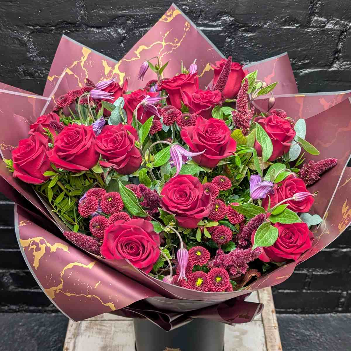 Velvet Night 2 Bouquet of deep red roses and burgundy filler flowers in dark wrapping